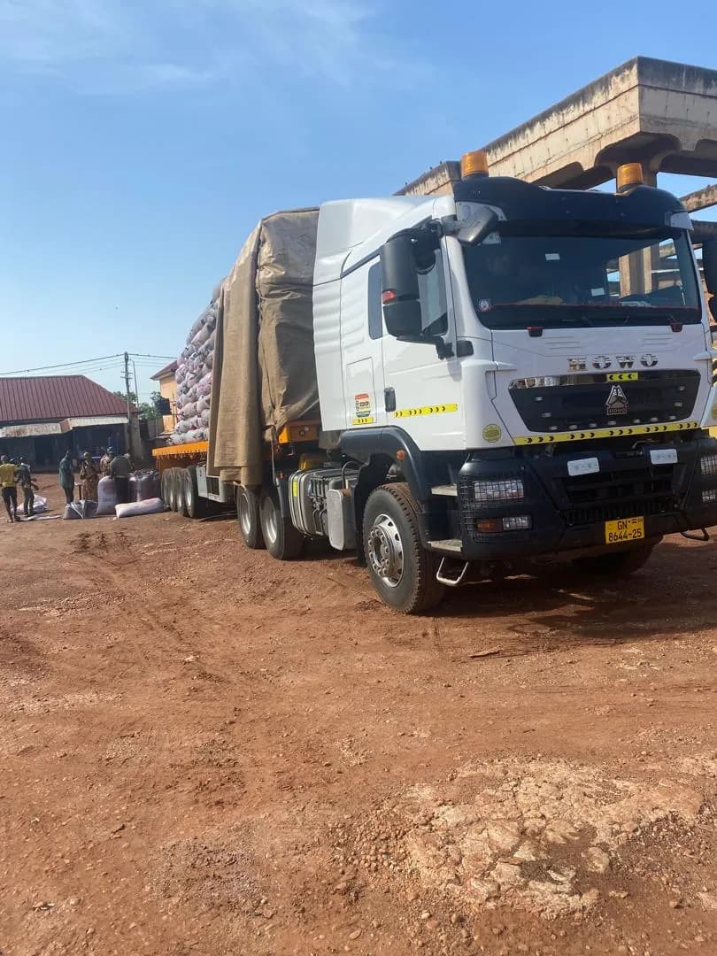 A loaded haulage truck at the depot, sacks stacked under tarpaulin, being readied to head south